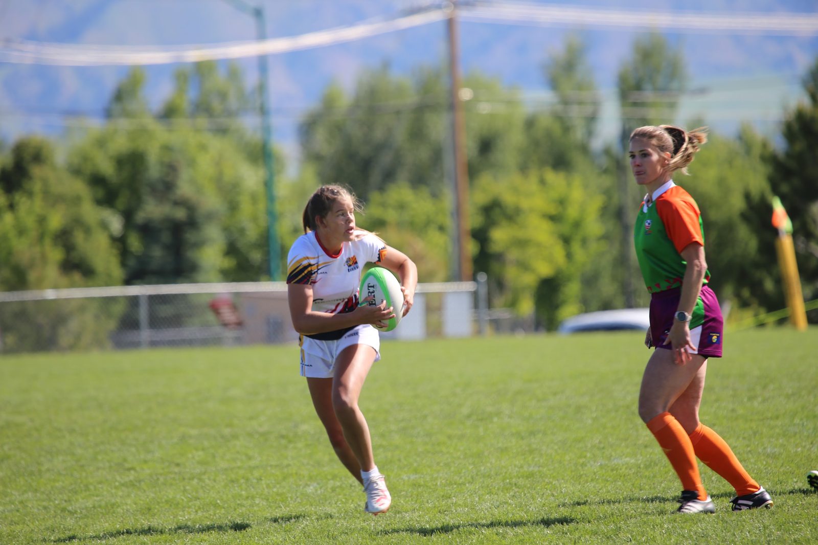 A player looks to pass as the referee follows play